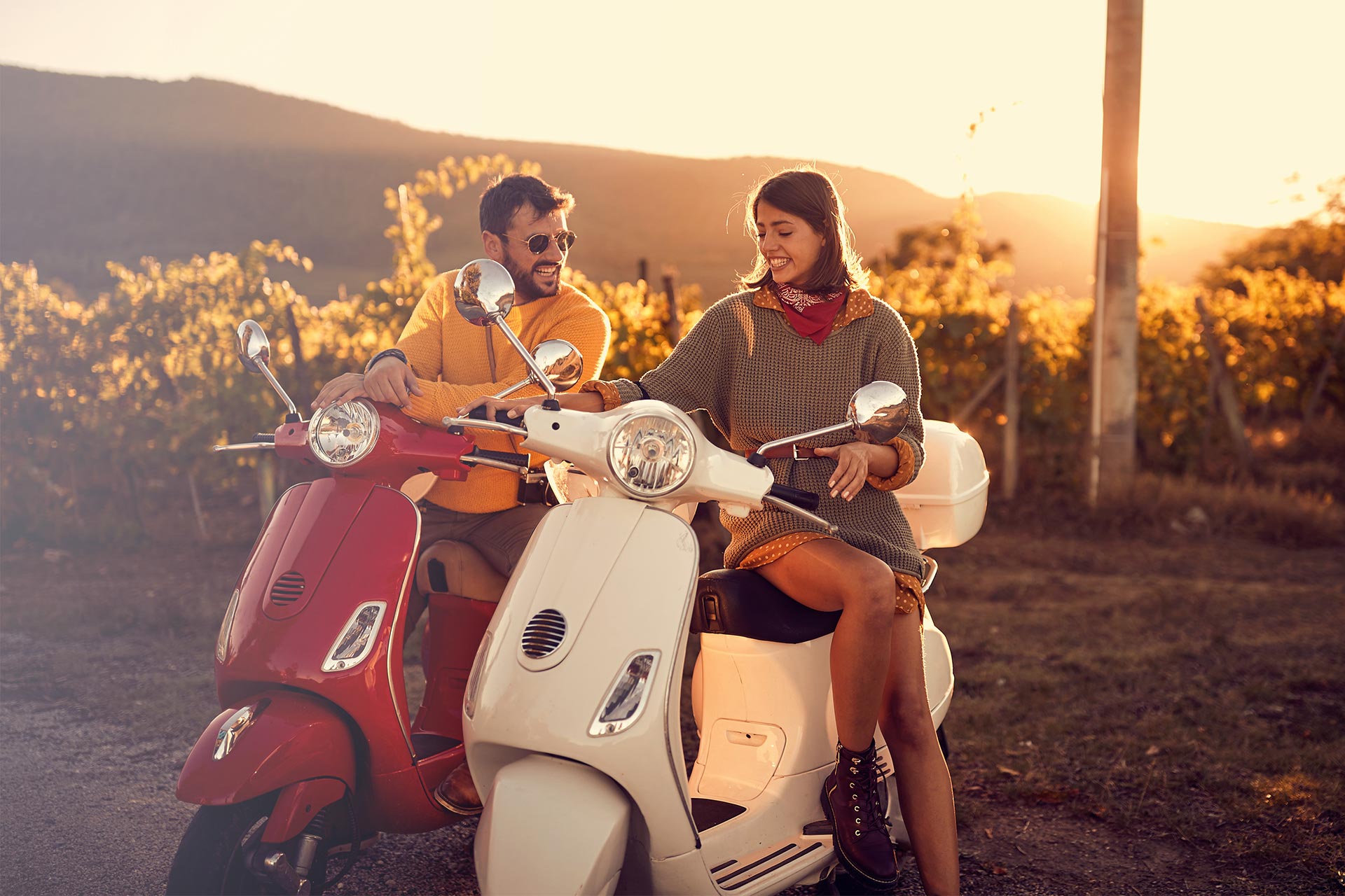 Homem e mulher em moto ao pôr do sol